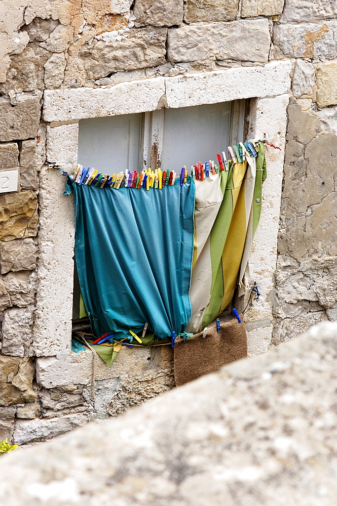 Stone window frame with hanging washing in Dubrovnik, Croatia, Europe