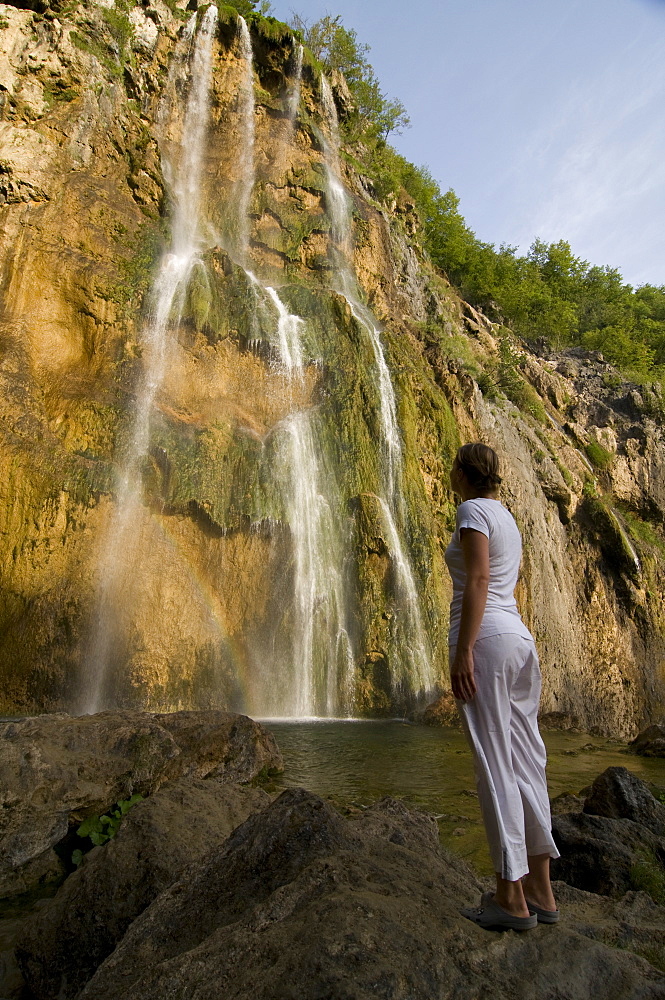 Woman looking at a giant waterfall, Plitvice Lakes National Park, UNESCO World Heritage Site, Croatia, Europe