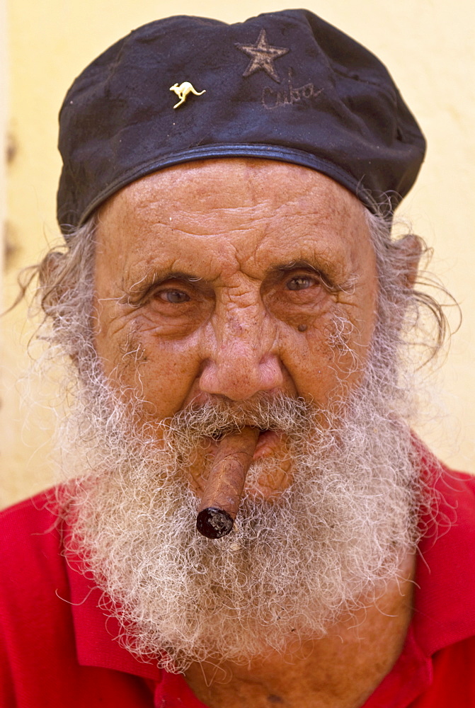 An old man with cap and white beard smoking a cigar, Havana, Cuba, West Indies, Central America