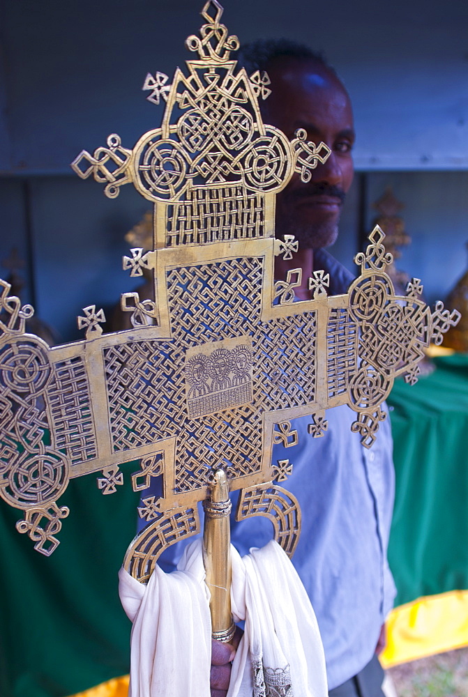 Orthodox monk standing behind a Christian cross, Axum, Ethiopia, Africa