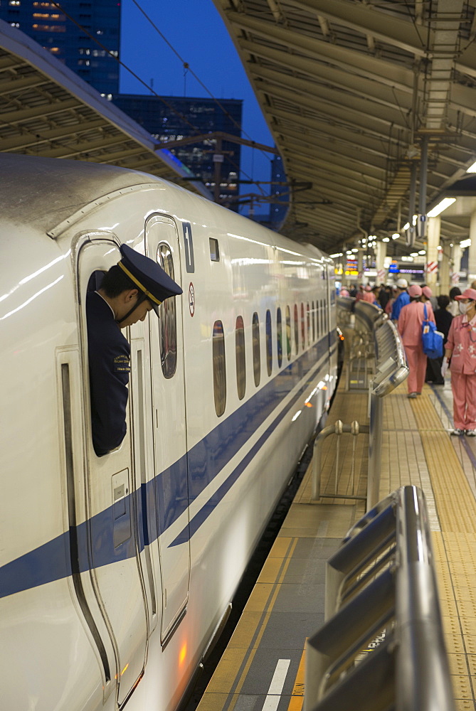 Train personnel looking out of the window of the Shinkanzen bullet train in the Shinkanzen train station in Tokyo, Japan, Asia