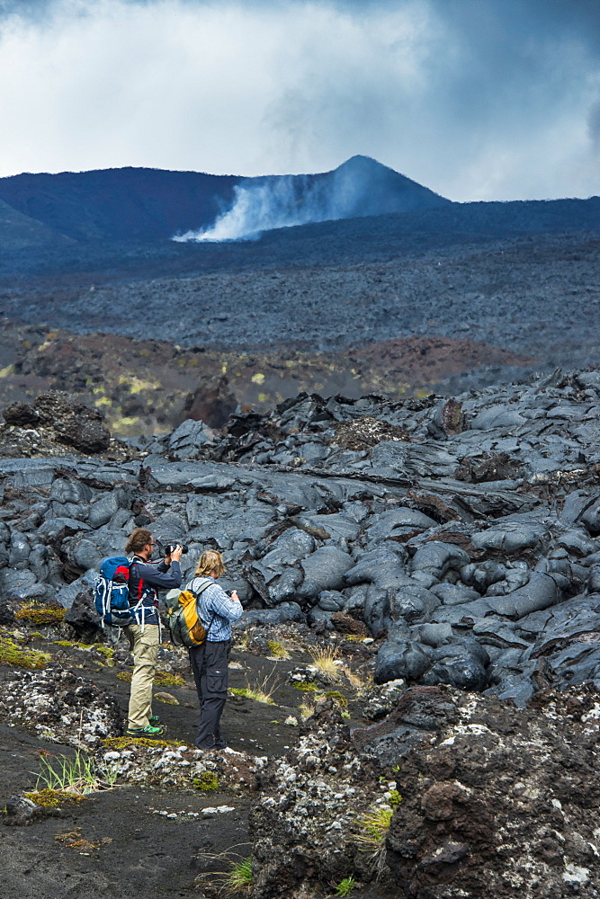 Tourists standing at a cold lava stream after an eruption of Tolbachik volcano, Kamchatka, Russia, Eurasia 