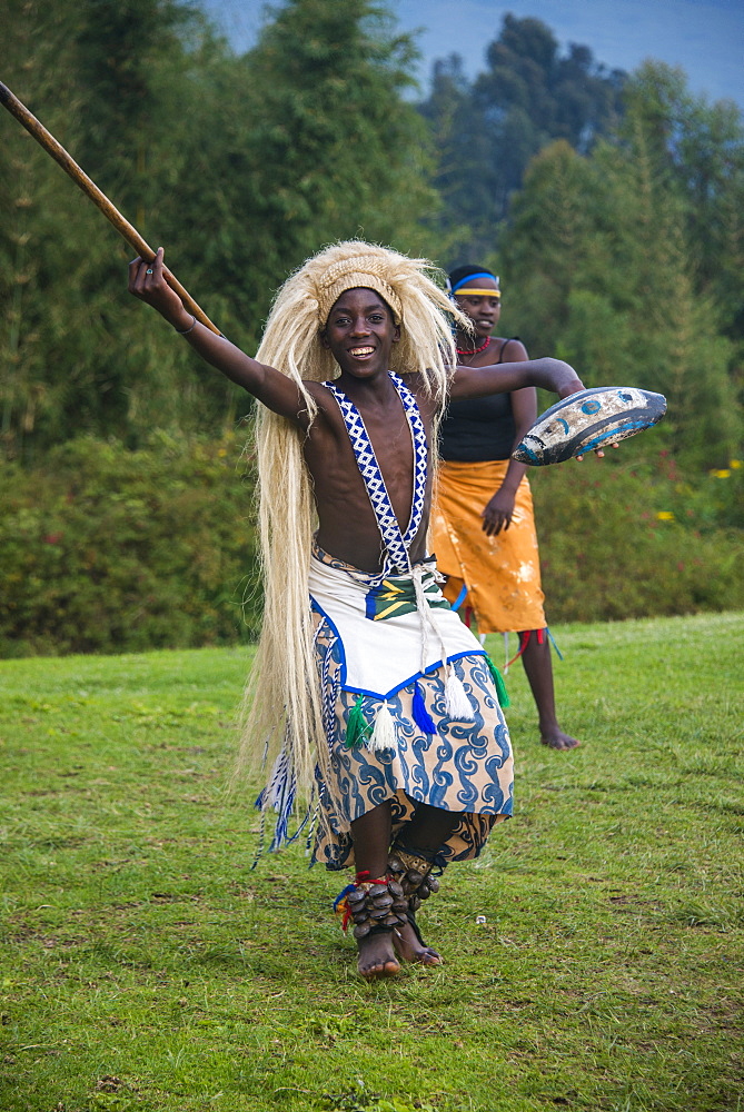 Man carrying a wig and a spear at a ceremony of former poachers, in the Virunga National Park, Rwanda, Africa