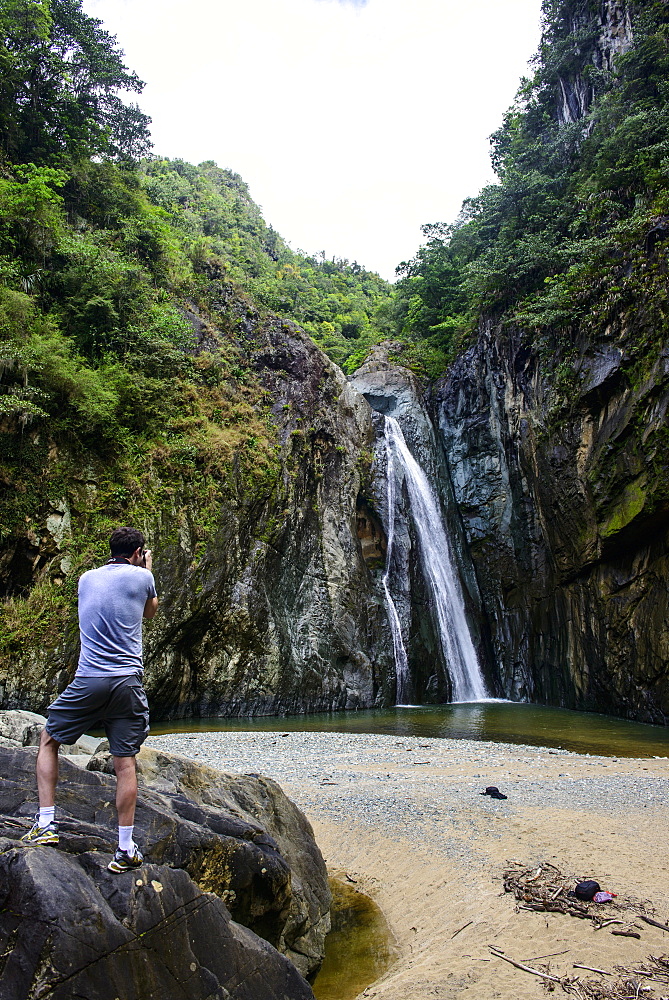 Man photographing the Jimenoa Uno waterfall, Jarabacoa, Dominican Republic, West Indies, Caribbean, Central America