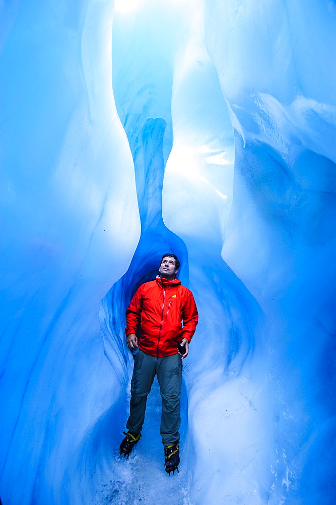 Man standing in an ice cave, Fox Glacier, Westland Tai Poutini National Park, South Island, New Zealand, Pacific