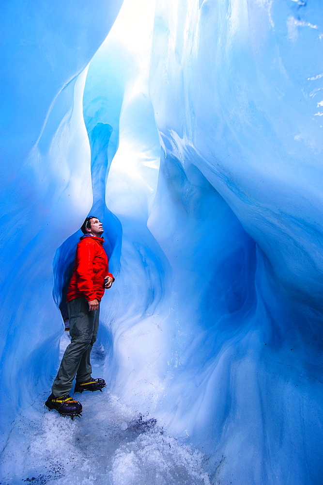 Man standing in an ice cave, Fox Glacier, Westland Tai Poutini National Park, South Island, New Zealand, Pacific