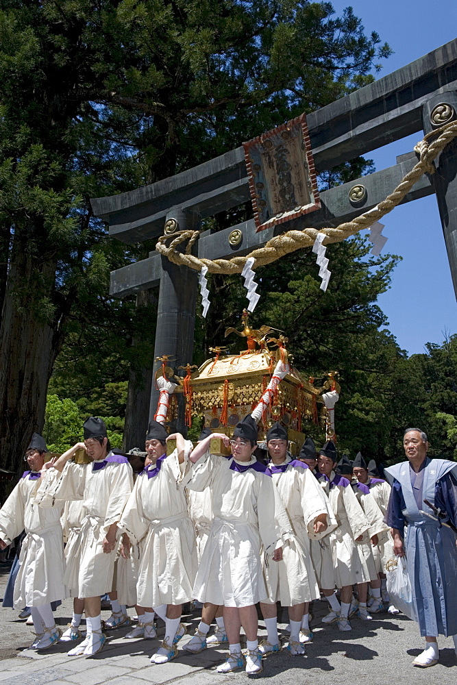 Mikoshi procession under torii gate at Futarasan Shrine during the Shunki Reitaisai festival in Nikko, Tochigi, Japan, Asia