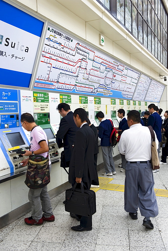 Passengers purchasing train tickets from vending machines at the JR Ueno railway station in Tokyo, Japan, Asia