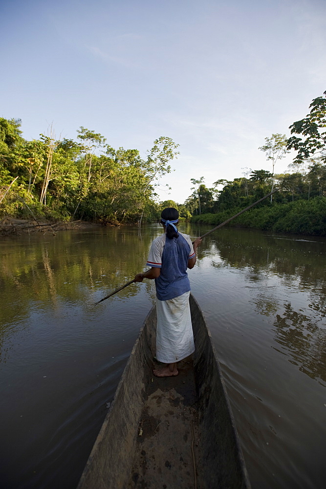 An Achuar man spear fishing on a tributary of the Amazon, Ecuador, South America