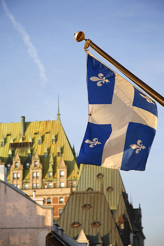 Quebec flag in foreground in front of rooftops of Chateau Frontenac, Quebec City, Quebec, Canada, North America