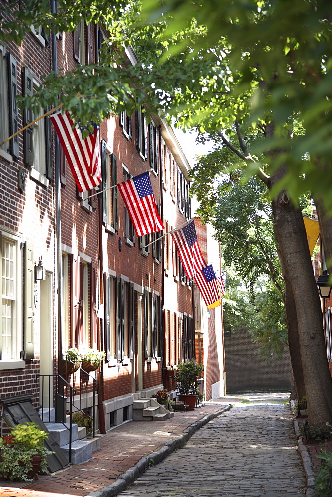 Flags displayed on homes on cobblestone American Street, in the Society Hill neighborhood of Philadelphia, Pennsylvania, United States of America, North America