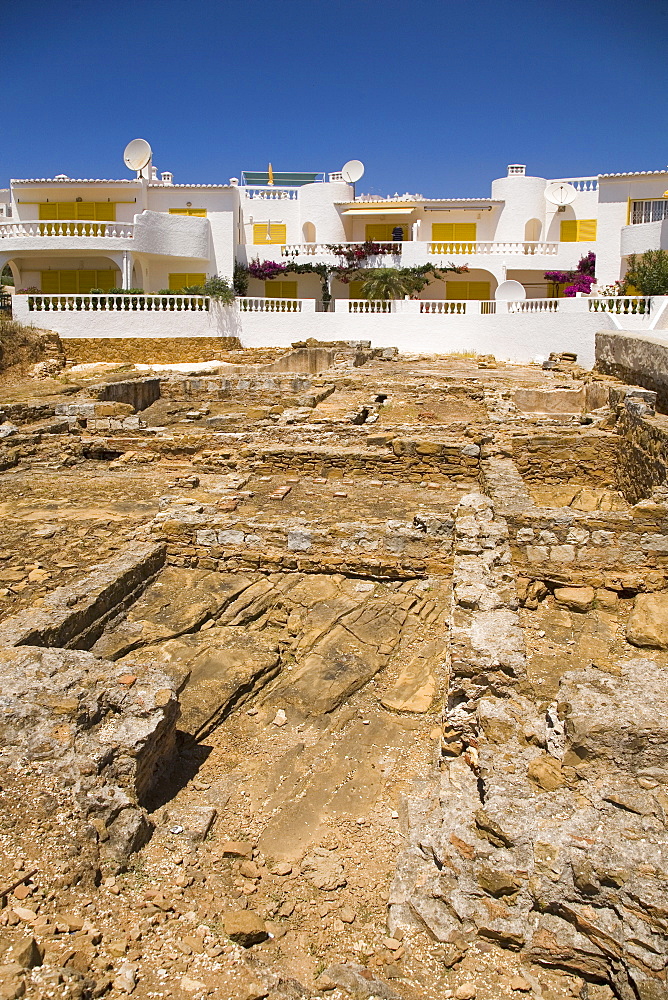 Modern apartments overlook the Roman ruins (the Ruinas Romanas da Luz) at Luz in Lagos, Algarve, Portugal, Europe