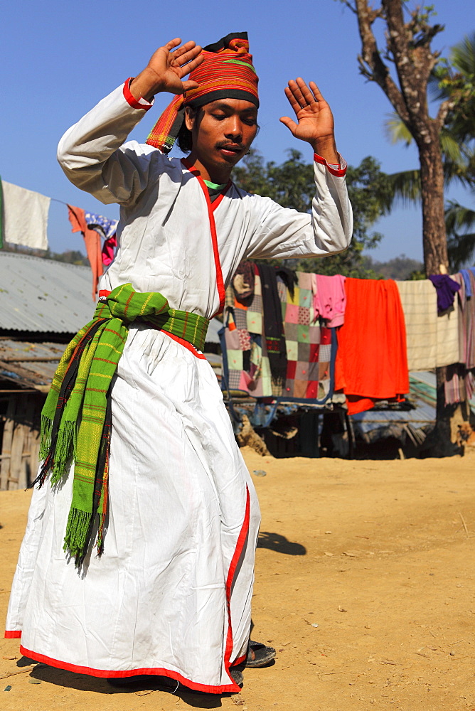 A Tripura tribesman performing a traditional dance wearing white robes, in their village in the Bandarban region of Bangladesh, Asiablack and white levels adjusted 