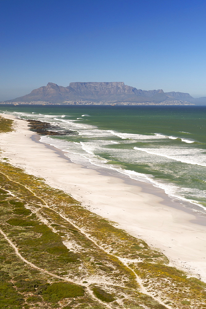 Aerial view along the coastline and beach of the Blaauwberg Nature Reserve on the west coast, north of Cape Town  with Table Mountain in distance across Table Bay, South Africa, Africa