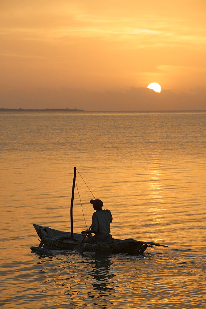 A man setting off in his one-man sailing boat (mitumbwi) in the Quirimbas archipelago in northern Mozambique, Indian Ocean, Africa