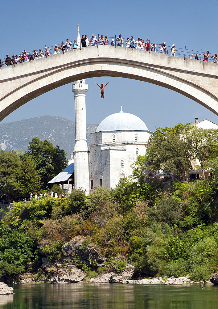 A diver jumping off the Stari Most (Old Bridge), a reconstructed 16th-century Ottoman bridge, UNESCO World Heritage Site, Mostar, Bosnia and Herzegovina, Europe