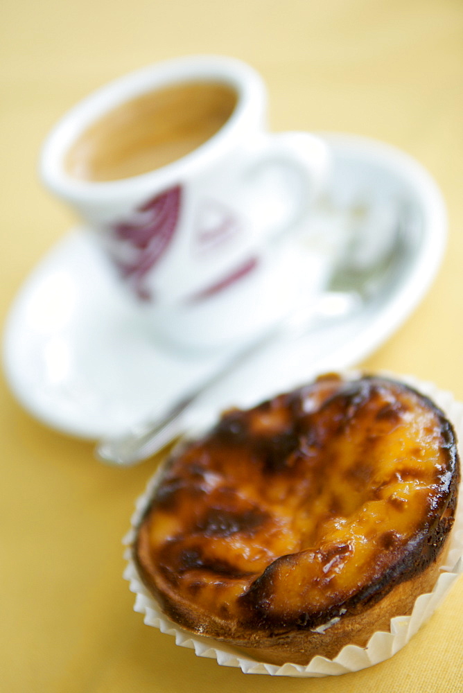 Cup of espresso and a pasteis de nata pastry in a Portuguese cafe.