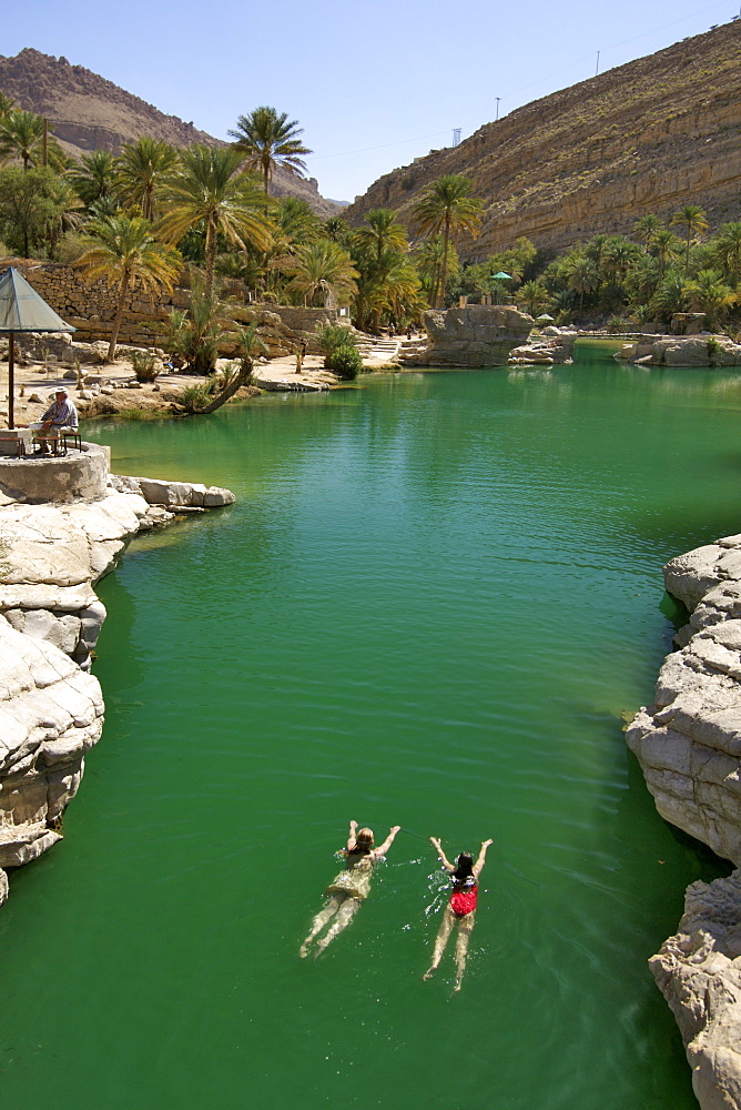 Two girls swimming in the turquoise pools of Wadi Bani Khalid in the eastern Hajar mountains (Al Hajar ash sharq) of the sultanate of Oman.