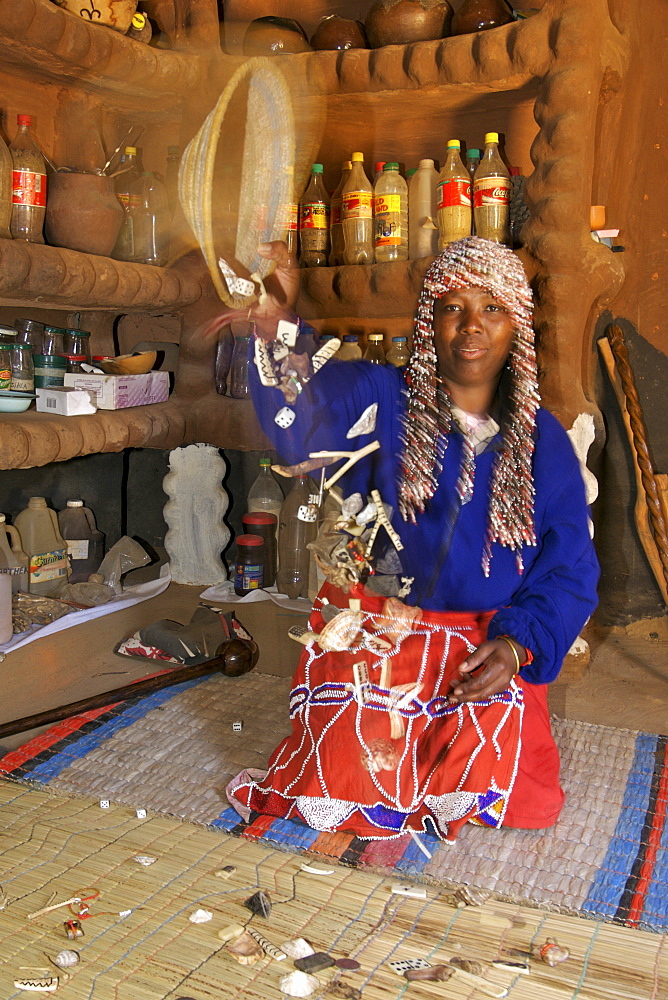 Aleta Thamae, a traditional sangoma, throwing various objects she will use to give a reading in her consultation room in her home in the township of Refilwe near Cullinan in South Africa.