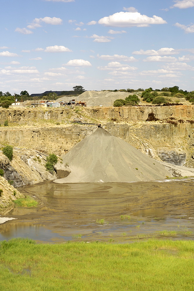 The De Beers diamond mine in Kimberley South Africa being filled with re-processed mine dump tailings from the De Beers combined treatment plant (CTP).