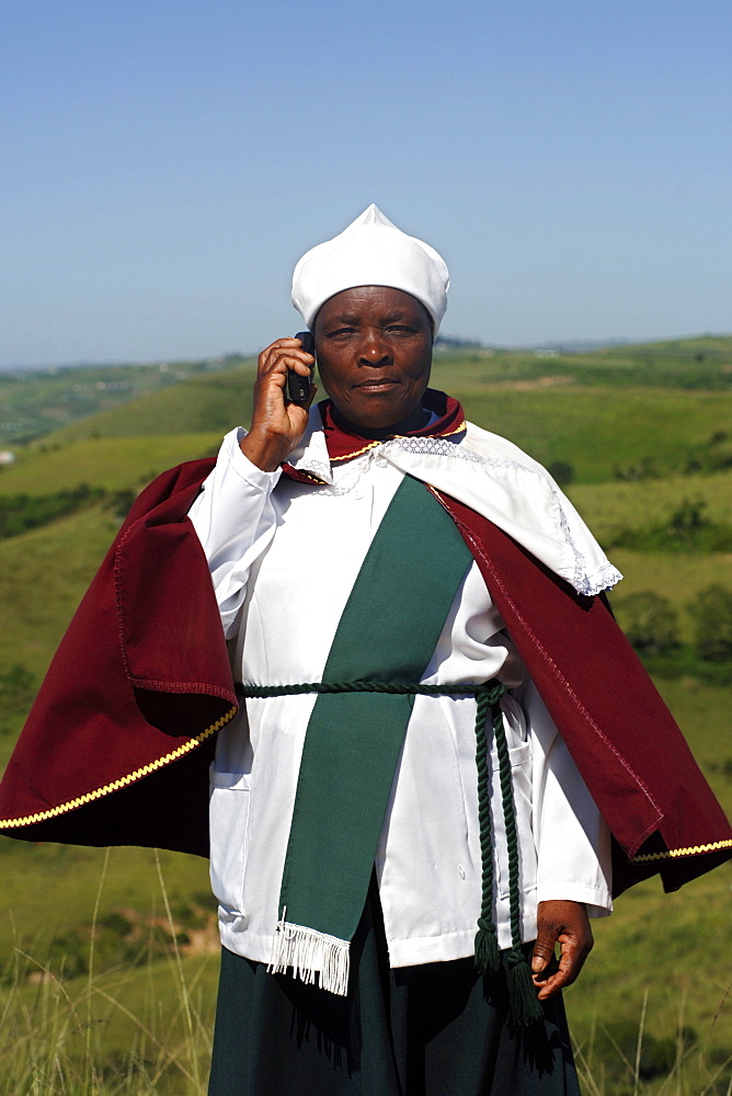 A Xhosa woman talks on her mobile/cell phone in the Eastern Cape Province of South Africa. This is an area along the Coffee Bay road in a region formerly known as the Transkei.