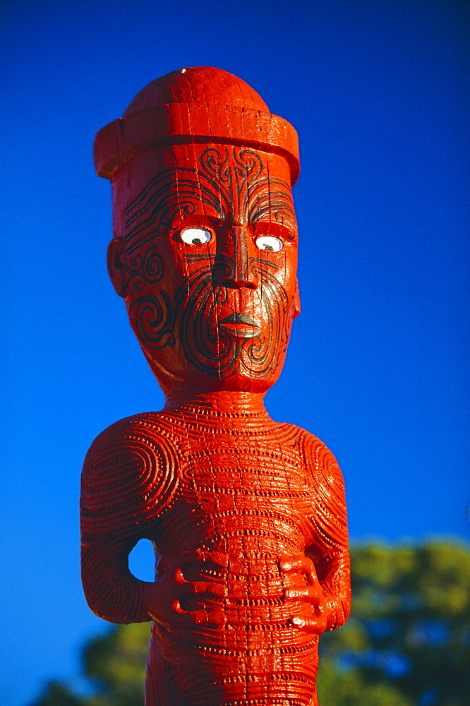 A carved figure, or poupou, in a Maori village at the Whakarewarewa thermal and cultural area of Rotorua, North Island, New Zealand