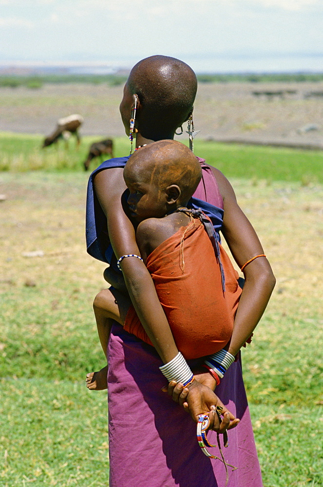 Teenage Masai mother carrying her child in a sling, Tanzania, East Africa, Africa