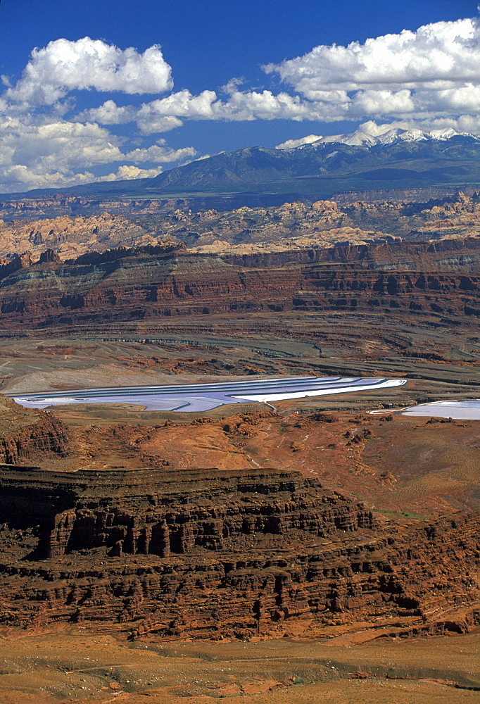 Looking from Dead Horse Point near Canyonlands National Park over the Colorado River canyon to the evaporation ponds at Potash. Mined salts are concentrated here for the extraction of potash for fertilizer, Dead Horse Point State Park, Utah, USA