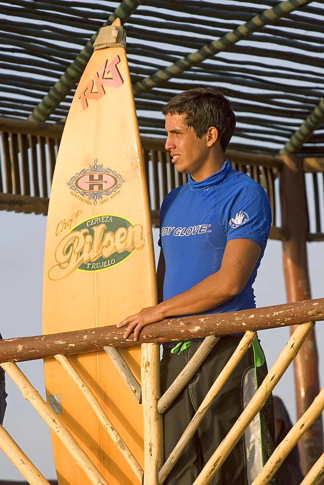 Surfer at the popular far north coast fishing & surfing village of Huanchaco, near Trujillo, Peru, South America.