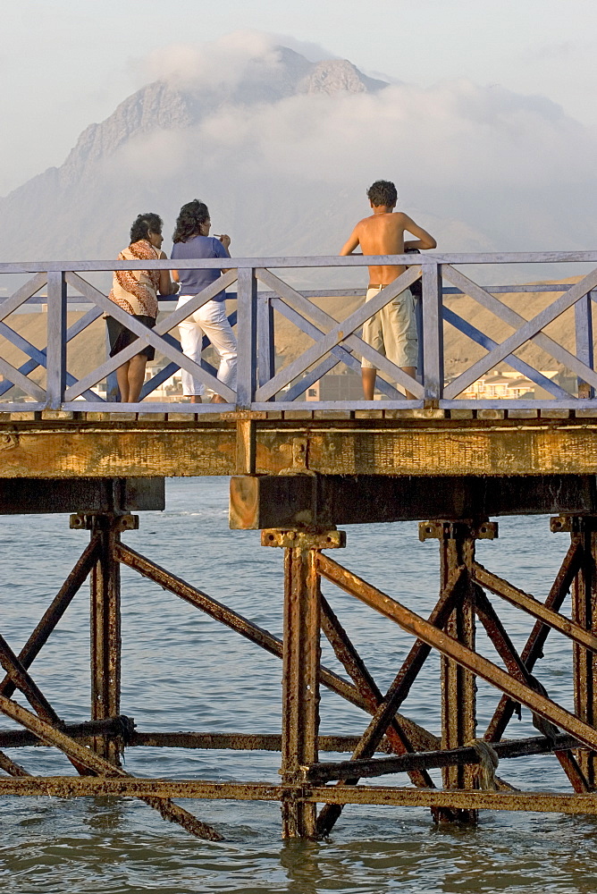 People on the pier at the popular far north coast fishing & surfing village of Huanchaco, near Trujillo, Peru, South America.