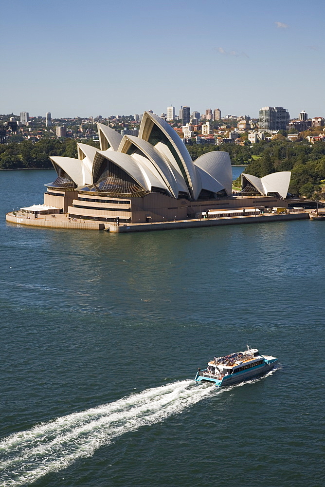 Sydney Opera House built in 1973, designed by Jorn Utzon, probably the most iconic symbol of the city, with a tourist ferry crossing the harbour towards nearby Circular Quay, Sydney, New South Wales, Australia, Pacific