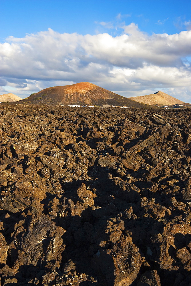 Irregular blocky lava (a'a) and cinder cones of the volcanic landscape of Timanfaya National Park, Lanzarote, Canary Islands, Spain, Atlantic Ocean, Europe