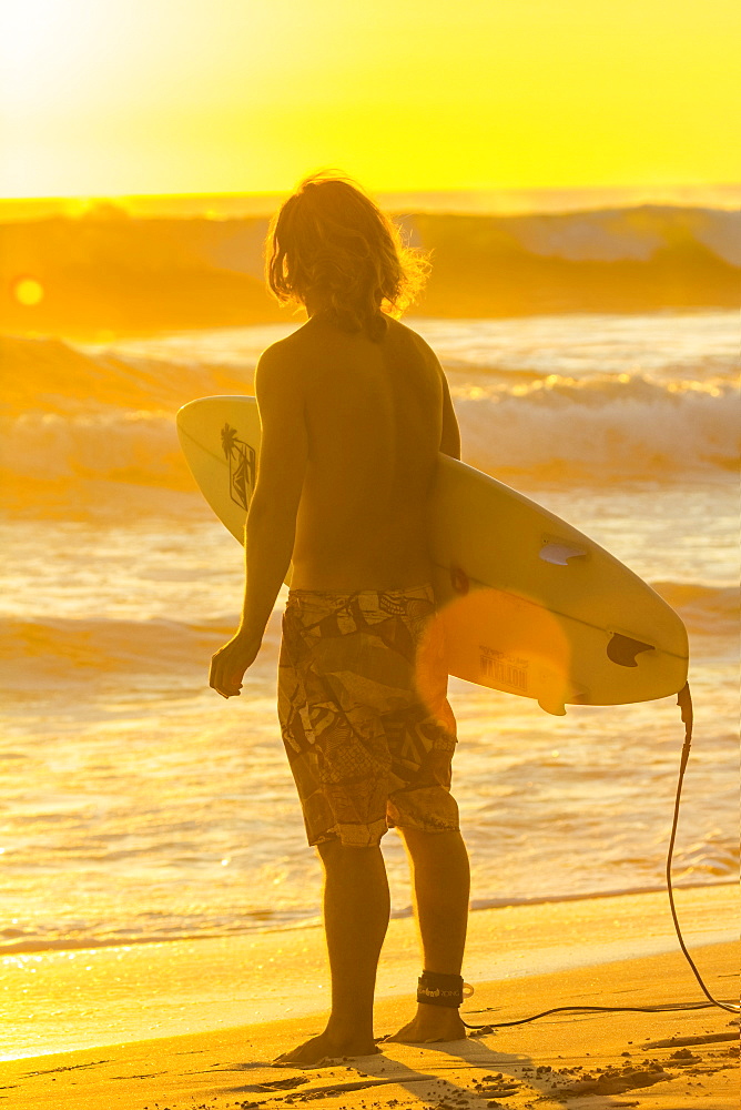 Surfer at sunset on this popular surf beach near Mal Pais on the Nicoya Peninsula, Playa Santa Teresa, Puntarenas, Costa Rica, Central America