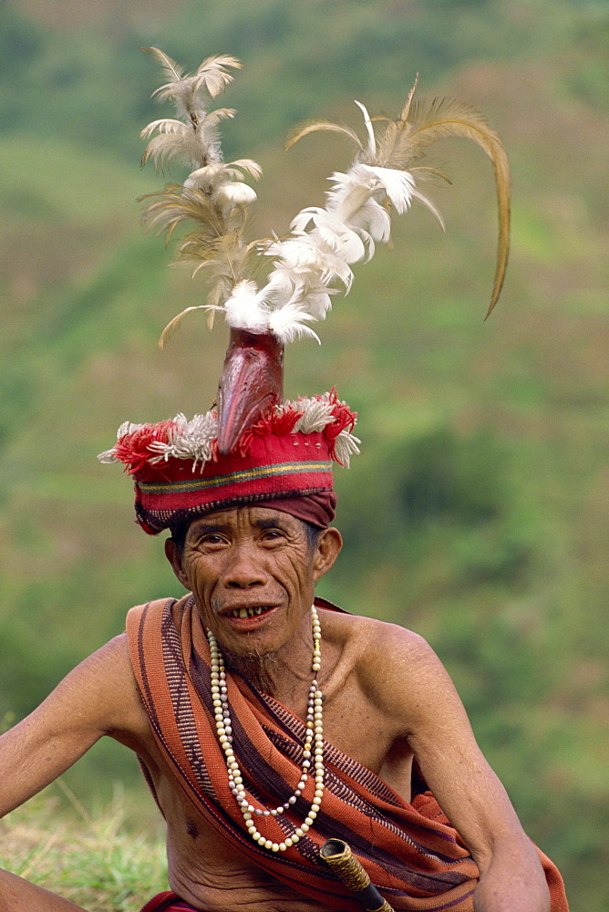 Portrait of an elderly man of the Ifugao tribe wearing a woven hat decorated with feathers and carved bird at Banaue, Mountain Province, north Luzon, Philippines, Southeast Asia, Asia