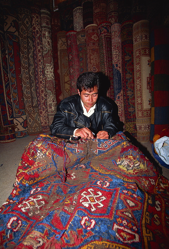 Man repairing carpet at a shop, Side, Anatolia, Turkey, Asia Minor, Eurasia