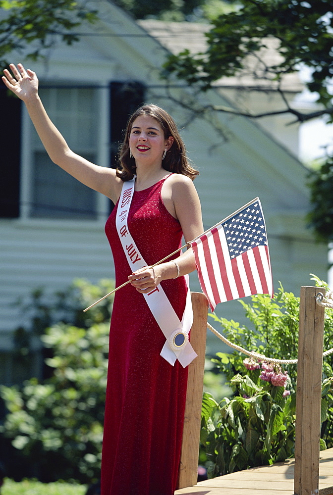 Fourth of July beauty queen with Stars and Stripes flag, waving to parade, Rhode Island, New England, United States of America, North America