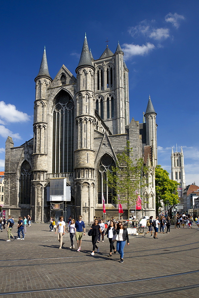 Young people enjoy summer sunshine in streets outside St. Nicholas' Church, city centre, Ghent, West Flanders, Belgium, Europe