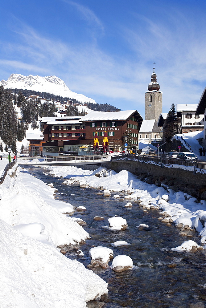 Hotel Krone, river and village church, Lech near St. Anton am Arlberg in winter snow, Austrian Alps, Austria, Europe