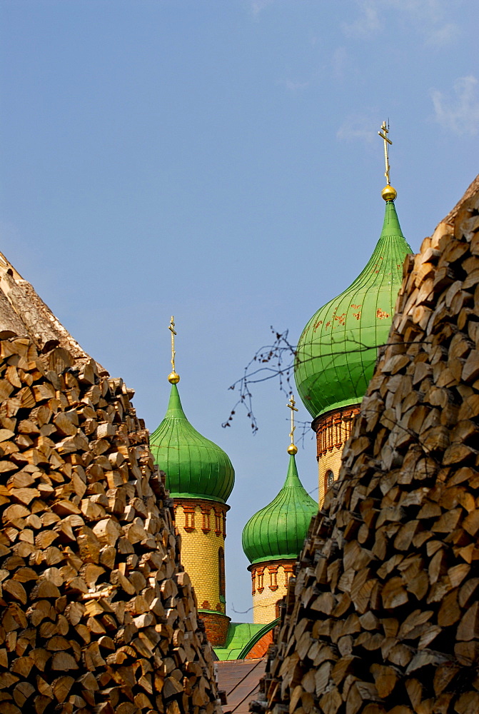 Church towers of the convent of Puehitsa behind two piles of wood, Puehitsa, north-east Estonia, Estonia, Northern Europe