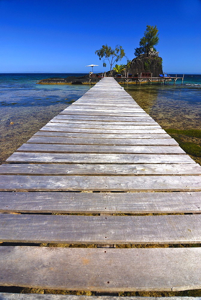 Jetty leading to a small rocky island with sunbeds, Santa Maria island, Madagascar, Africa