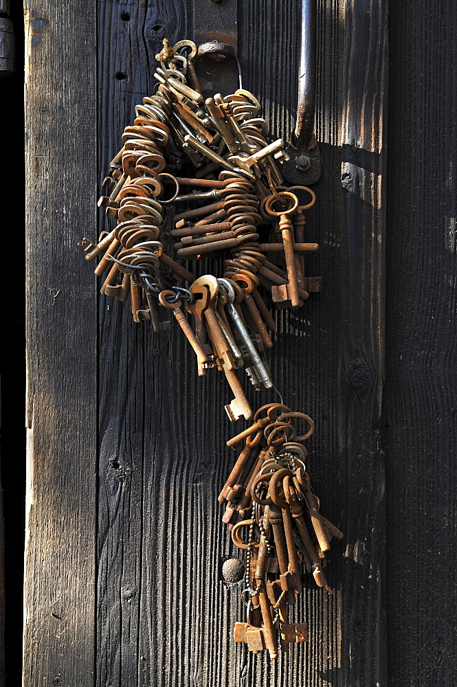 Rusty door keys hanging on a barn door