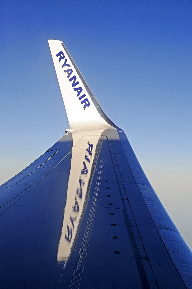 Ryanair, budget airline logo on the wing of a plane in the sky