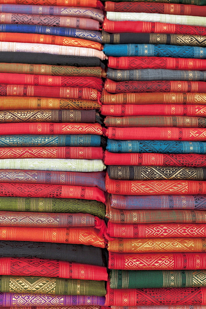 Colourful silk textiles on display at a market stall in Luang Prabang, Laos, Southeast Asia