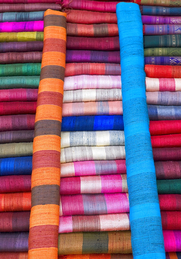 Colourful silk textiles on display at a market stall in Luang Prabang, Laos, Southeast Asia