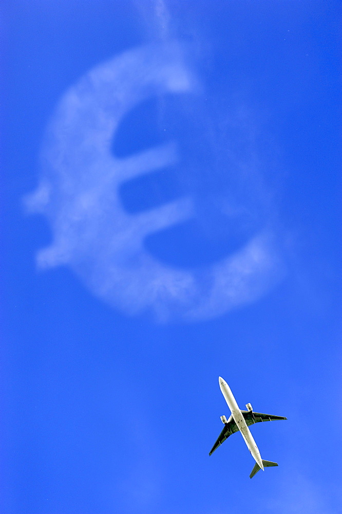 Aircraft flying against a blue sky with a Euro sign, symbolic image for aviation tax