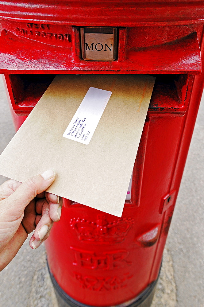 Posting a letter into a red post box, United Kingdom, Europe