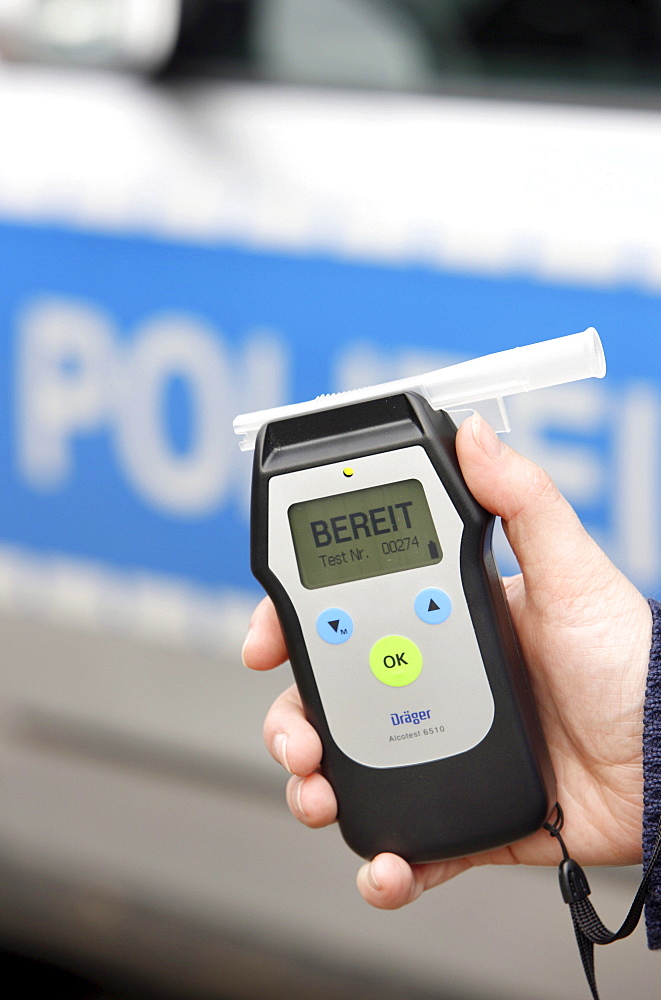 Police officer with breathalyser for checking the fitness to drive