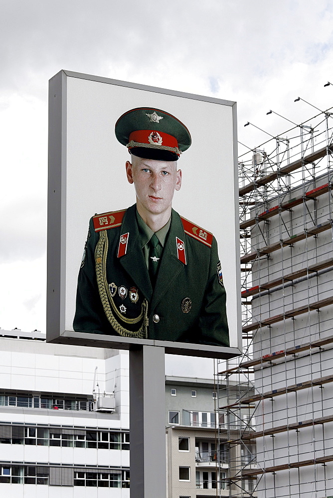 Advertising billboard with a large photo of a soldier wearing the uniform of the former Soviet army, Checkpoint Charlie, Berlin-Mitte, Germany, Europe