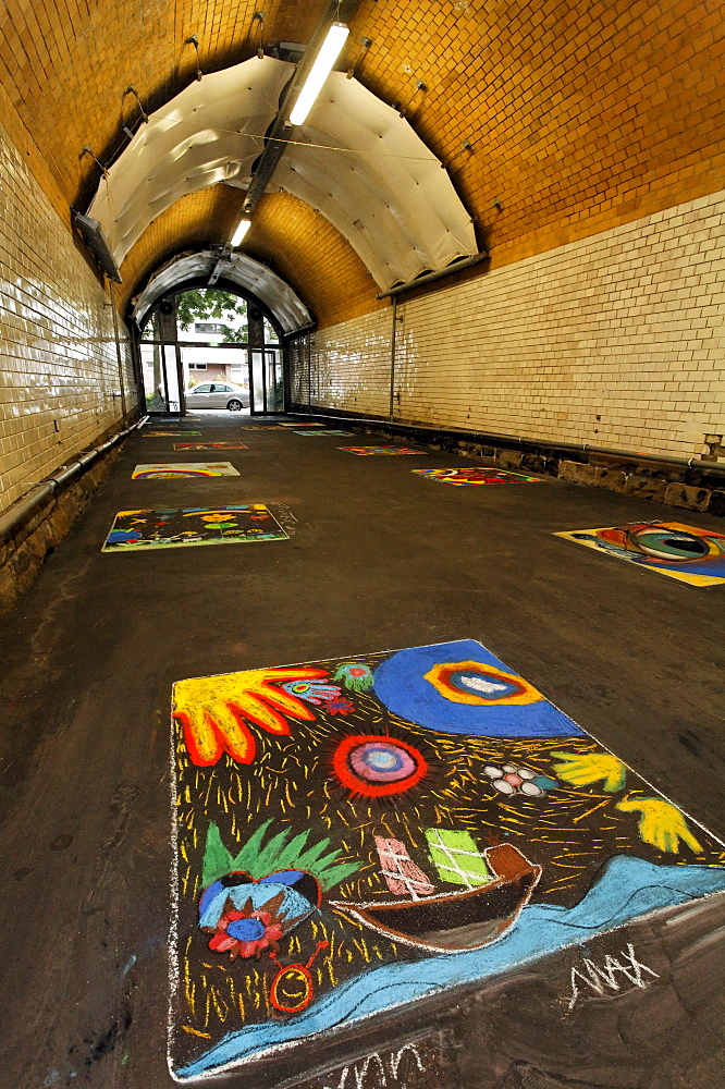 Pedestrian tunnel with chalk drawings on the ground, painted by children, disused Suedbahnhof railway station, Krefeld, North Rhine-Westphalia, Germany, Europe