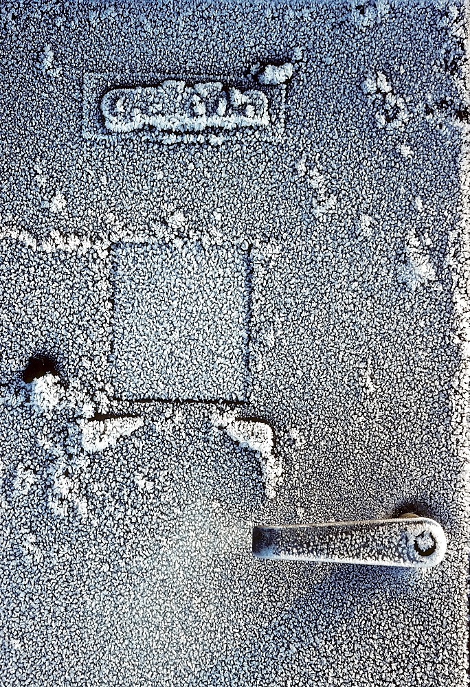 Old steel cabinet with a handle, coated with frost, industrial ruin